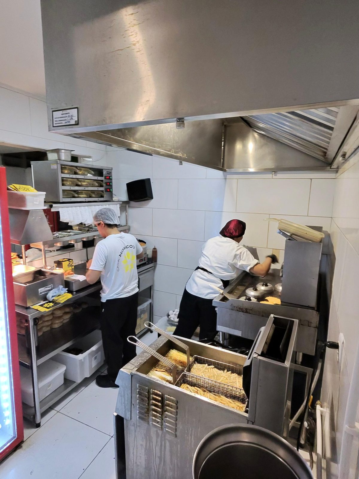 Cozinha do delivery com chapa, fritadeira e embalagens